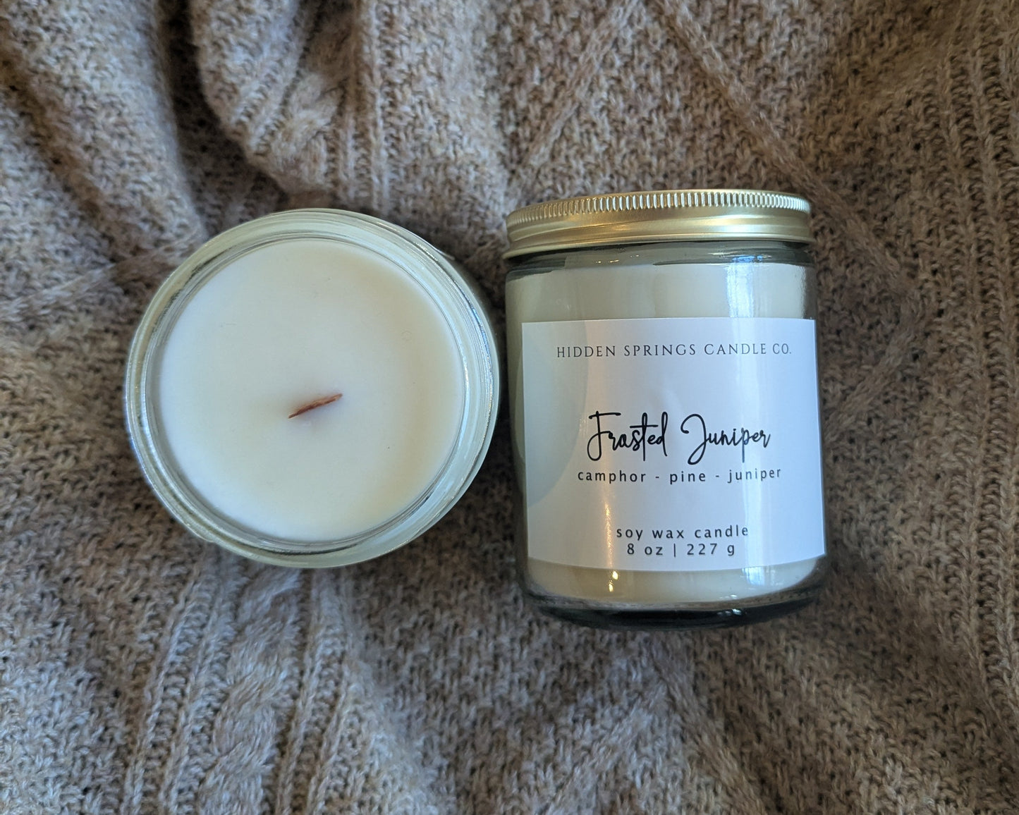 Two candles on a textured fabric surface