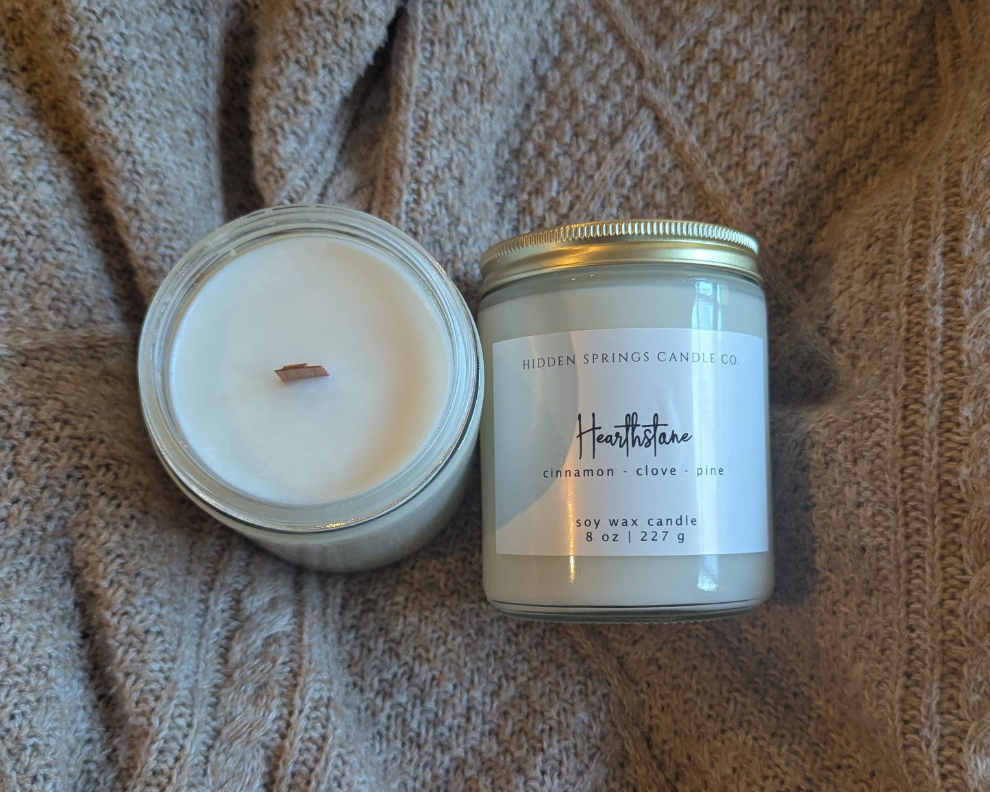 Two candles on a textured fabric surface