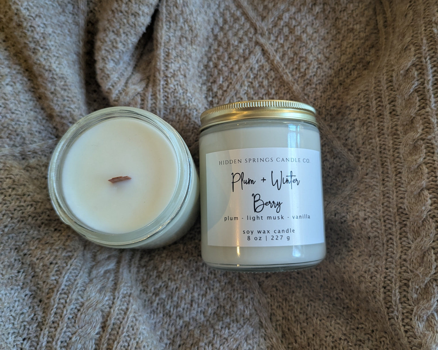 Two candles on a textured fabric surface