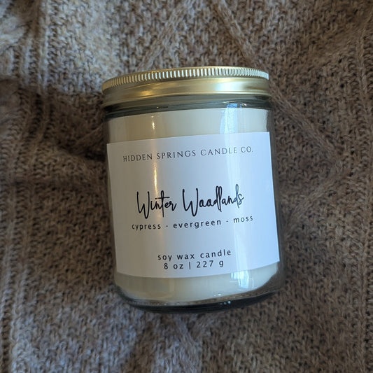 Candle jar with a label on a textured fabric background